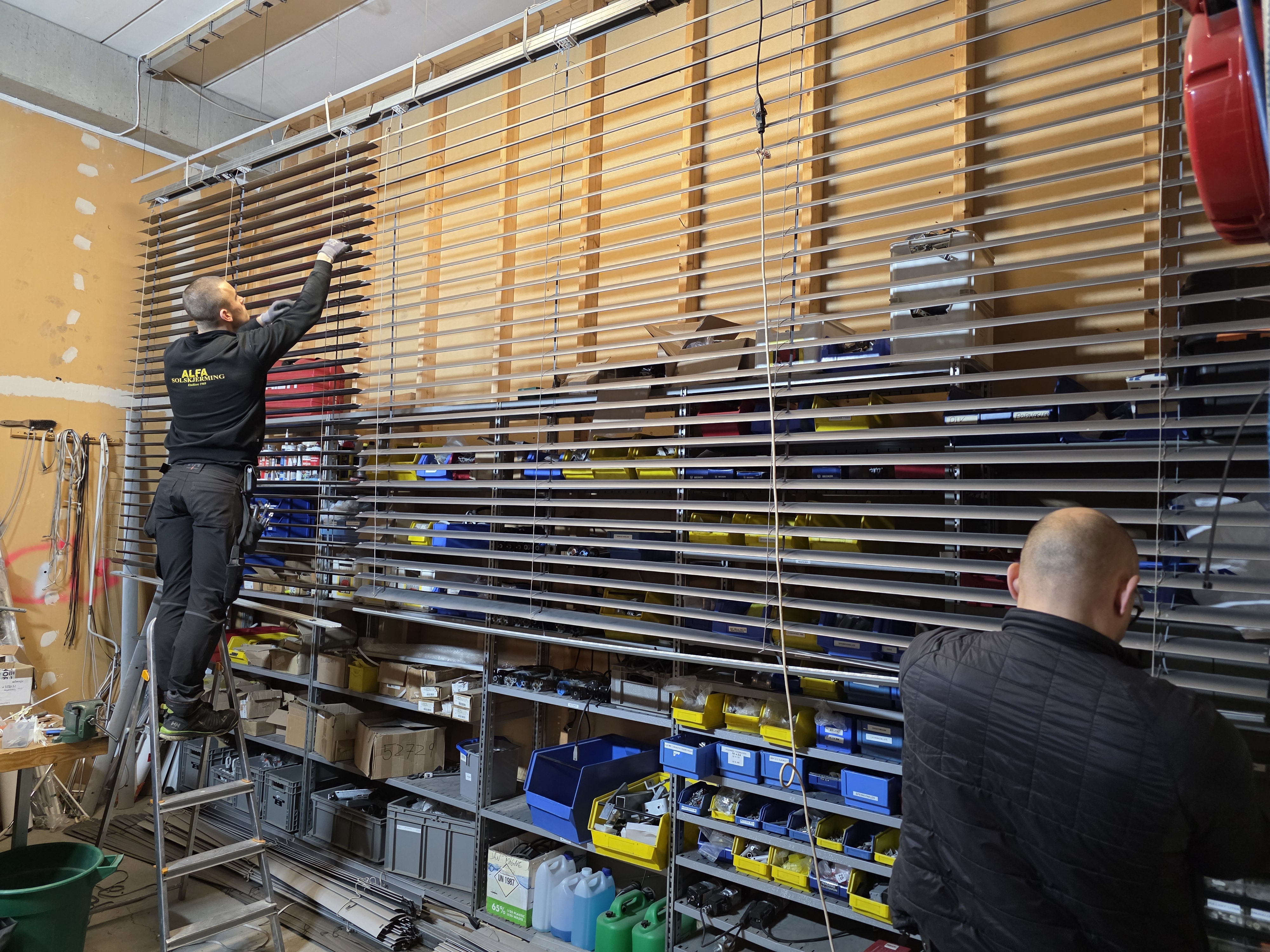 Alfasol-medarbeidere arbeider med store persienner i verkstedet